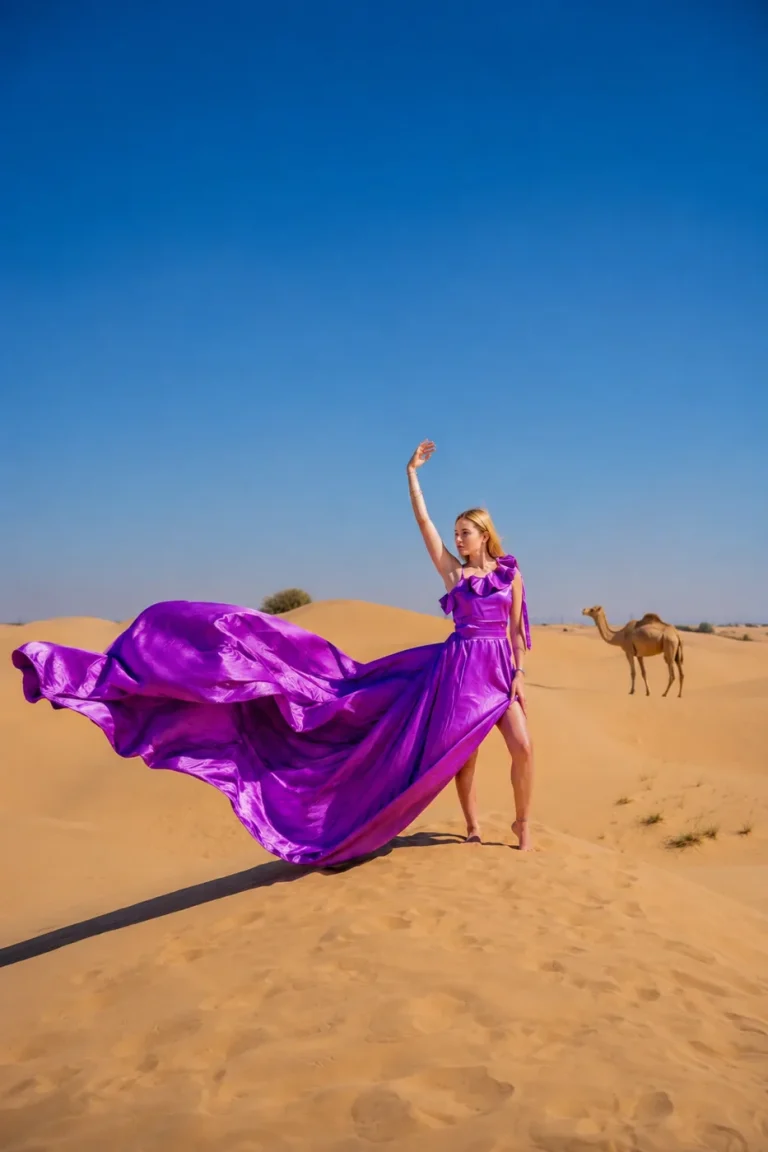 Purple flying dress photoshoot with a dramatic pose on Dubai sand dunes